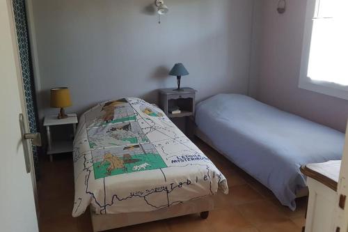 - une petite chambre avec un lit et un couvre-lit dans l'établissement Ambiance bord de mer, à Saint-Georges-de-Didonne