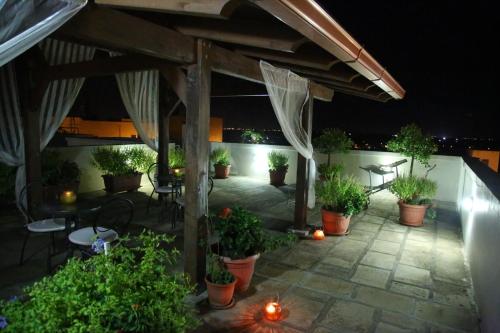 a patio with potted plants and a table and chairs at B&B Borgosolare in Specchia