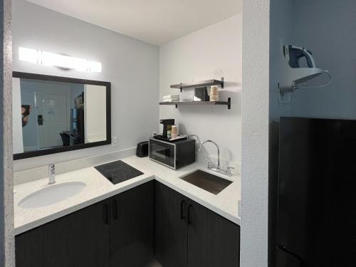 a bathroom with a sink and a microwave at Studio 6 Conroe, TX in Conroe