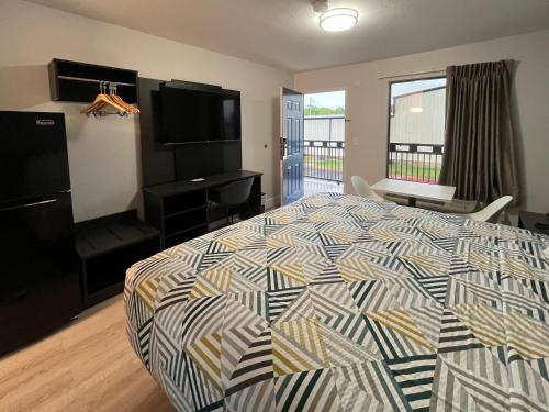 um quarto com uma cama e uma televisão de ecrã plano em Studio 6 Conroe, TX em Conroe