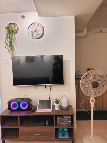 a flat screen tv hanging on a wall with a fan at Lazy Cabin PH in Manila