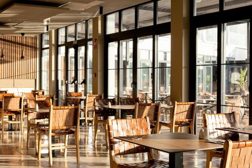 アルクーディアにあるSunprime Pollensa Bayのテーブルと椅子、窓のあるレストラン