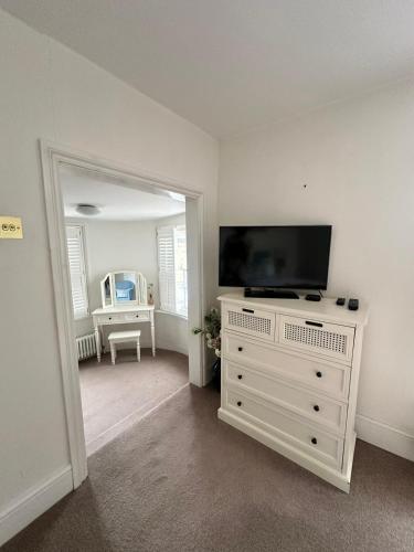 a living room with a flat screen tv on a dresser at Tower House, Cowes Old Town in Cowes
