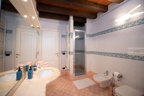a bathroom with a sink and a tub and a toilet at Casa sul Porto in Desenzano del Garda