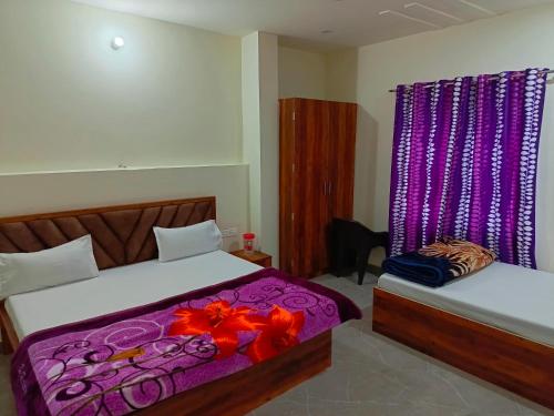 a bedroom with two beds with purple sheets and flowers at Shri Girraj Residency in Mathura