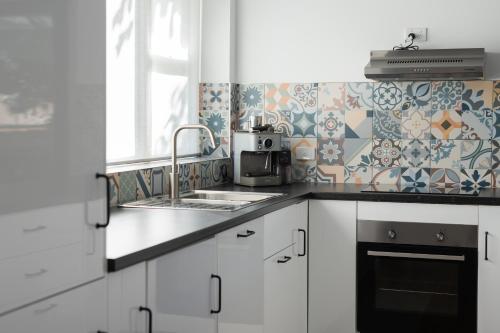 a kitchen with white cabinets and a sink at Derby Bank House- Heritage listed two bedroom old school B&B suite or a self contained cabin in Derby