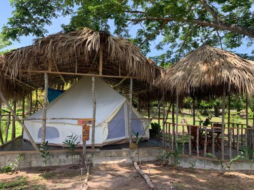 a tent with a straw roof and a table at Humble Boy retreat Glamping yurt in Negril