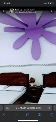 Khách sạn Hoà Bình في Cà Mau: غرفة نوم مع فراشة أرجوانية على الحائط
