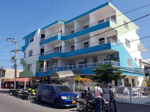 un edificio azul y blanco con motocicletas estacionadas frente a él en HOTEL HERNANDO HENRY en San Andrés