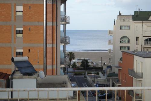una vista sulla spiaggia dal balcone di un edificio di Stupido Hotel Rimini a Rimini