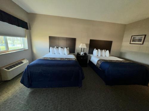 a hotel room with two beds and a window at Garner INN & Suites in Garner