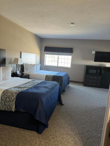 a hotel room with two beds and a flat screen tv at Garner INN & Suites in Garner
