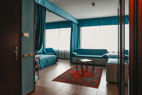 a room with a bedroom with a bed and a couch at Hotel Dante Family Spa Resort in Cervia