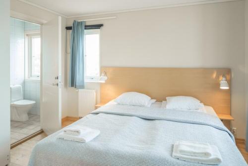 a bedroom with a large bed with two towels on it at Ekenäs Havshotell Koster in Sydkoster