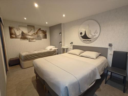 um quarto de hotel com duas camas e uma cadeira em Au Jardin d'Edel Gîtes Centre Alsace em Dieffenthal