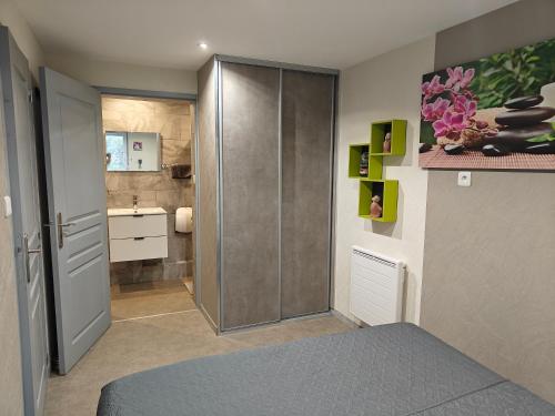 1 dormitorio con puerta corredera y baño en Au Jardin d'Edel Gîtes Centre Alsace, en Dieffenthal