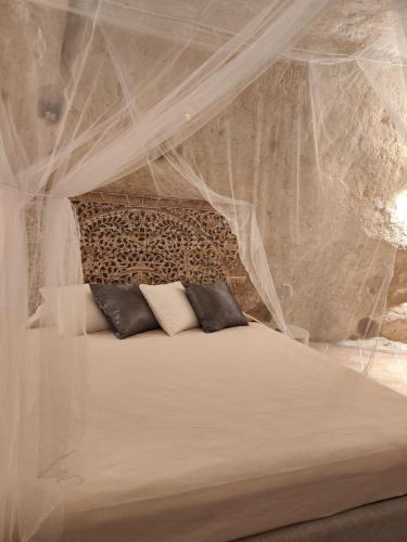 a bedroom with a bed covered in mosquito nets at Stone House in Matera