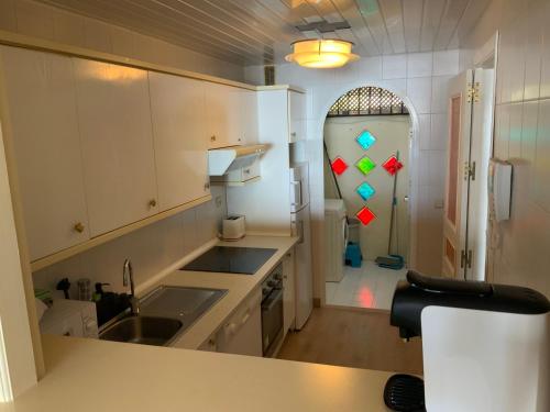 a kitchen with white cabinets and a counter top at Piso islas C111 in Benalmádena