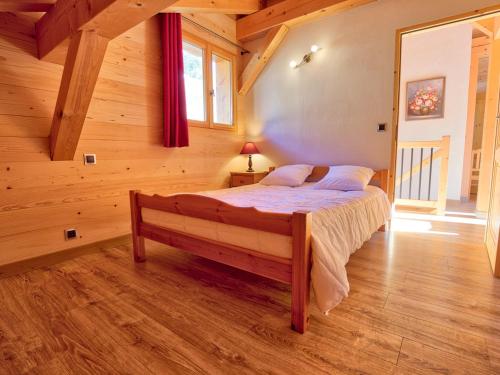 a bedroom with a bed in a wooden cabin at Chalet Notre-Dame-de-Bellecombe, 5 pièces, 8 personnes - FR-1-505-66 in Notre-Dame-de-Bellecombe