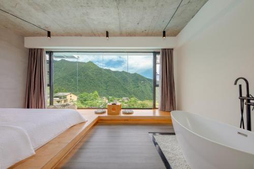 a bedroom with a bed and a large window at Avatar Mountain Resort in Zhangjiajie