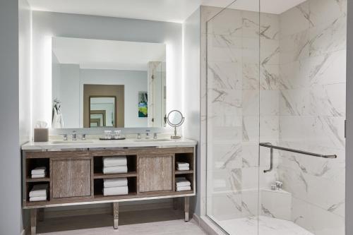 a bathroom with a sink and a shower at HOTEL PASEO, Autograph Collection in Palm Desert