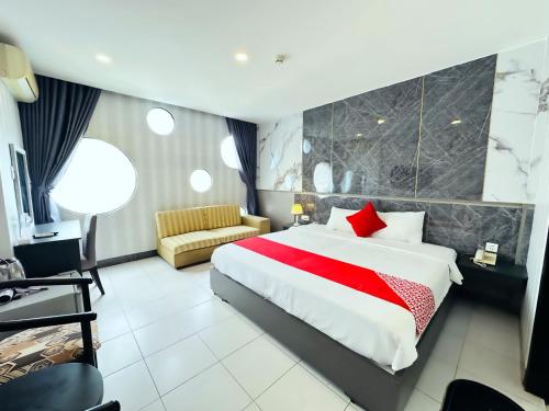 een hotelkamer met een groot bed en een bank bij Centara Saigon Hotel - 270 Ly Tu Trong in Ho Chi Minh-stad