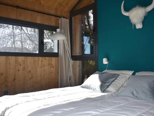 een slaapkamer met een bed en een blauwe muur bij Chalet Font-Romeu-Odeillo-Via, 4 pièces, 8 personnes - FR-1-580-111 in Font Romeu Odeillo Via