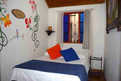a bedroom with a bed with colorful pillows on it at FILANDIA HOTEL in Filandia