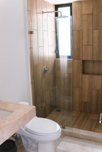 a bathroom with a toilet and a shower at Luxury 3BR Oceanfront Retreat - Pool, Views & Private Beach Access in Chicxulub