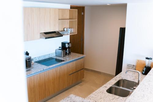een keuken met een spoelbak en een aanrechtblad bij Luxury 3BR Oceanfront Retreat - Pool, Views & Private Beach Access in Chicxulub