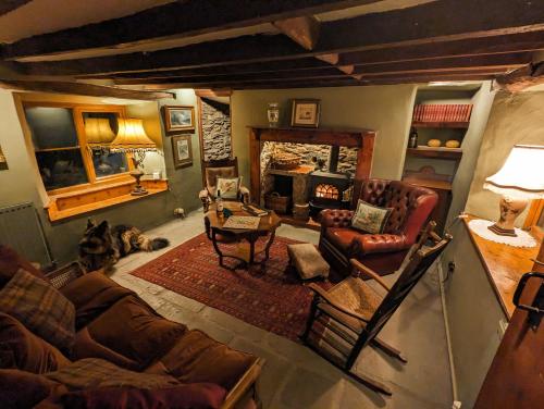 sala de estar con sofás de cuero y chimenea en Voulwill Cottage en Lynton