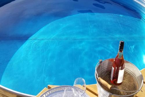 a bottle of champagne in a bucket next to a pool at Global Village Permaculture BnB in Oliver