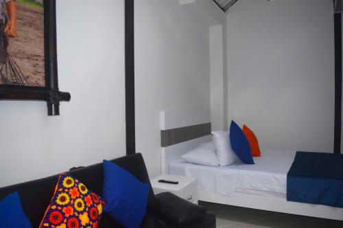 a small bedroom with a bed and a couch at FILANDIA HOTEL in Filandia