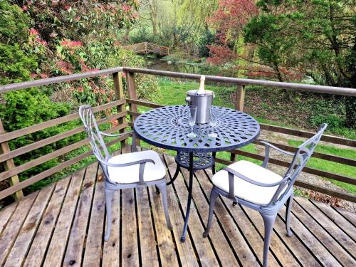 a table and two chairs on a wooden deck at Y Caban at Wig Farm near Llangrannog in Llandysul