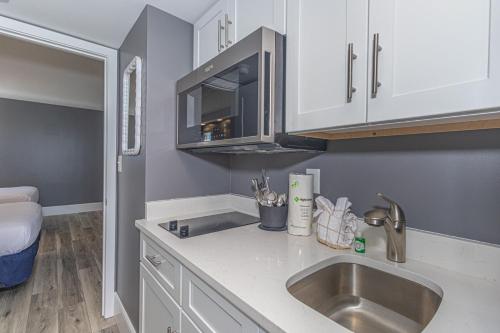 a kitchen with a sink and a microwave at Oceanfront One Bedroom Suite-Atlantica 803 in Myrtle Beach