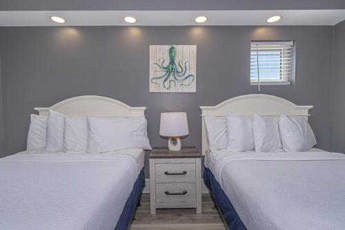 a bedroom with two beds and a table with a lamp at Oceanfront One Bedroom Suite-Atlantica 803 in Myrtle Beach