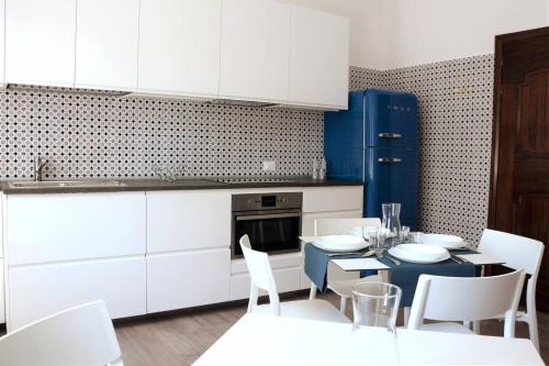 a kitchen with white cabinets and a table and chairs at dimora scaldaferro in Mira