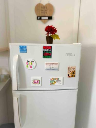 a white refrigerator with magnets and a flower on top at Cozy apartment near Seminole Hard Rock Cafe in Hollywood