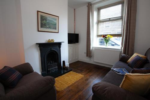 a living room with a couch and a fireplace at Spacious 3 bedroom Cottage in Whalley in Whalley