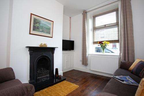 een woonkamer met een open haard en een raam bij Spacious 3 bedroom Cottage in Whalley in Whalley