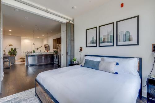 a bedroom with a large white bed and a kitchen at Lofts at 30th - 2 Top Floor Units in Nashville