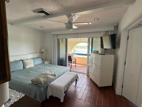 a bedroom with a bed and a door to a balcony at St Thomas -Spectacular Views of St John- Ocean Front! in St Thomas
