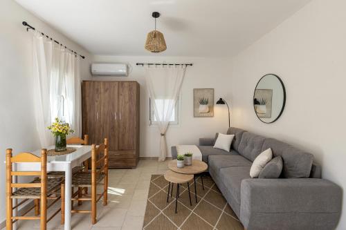 ein Wohnzimmer mit Sofa und Tisch in der Unterkunft Salty Beach Cottage, 20m from Kini Beach in Ano Syros