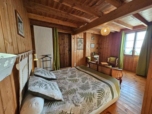 a bedroom with a bed in a wooden cabin at Les Gravets in Sigalens