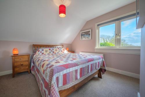 a bedroom with a bed and a window at The Bird House - Coastal Lodge in lovely Forest Setting nr. Kinsale in Cork