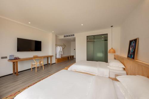 a bedroom with two beds and a flat screen tv at Avatar Mountain Resort in Zhangjiajie