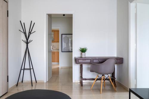 a living room with a desk and a chair at SummerVibes Penthouse Varkiza in Vari
