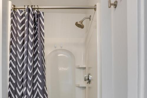 a shower door with a black and white shower curtain at Weymouth Apartment Close to Beaches and Boston! in Weymouth