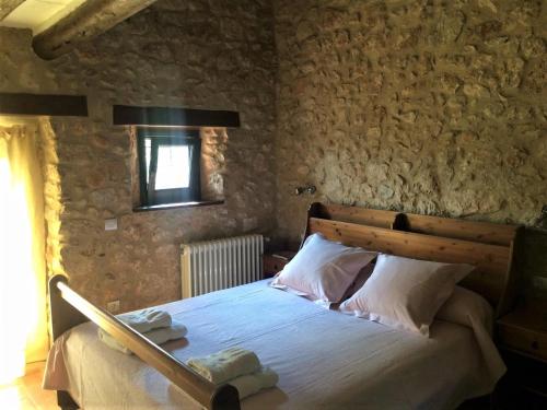 a bedroom with a wooden bed with towels on it at Mas Coquells Rural - Habitació doble amb bany i terrassa privada in Vilanant