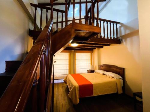a bedroom with a staircase and a bed in a room at Casa Bonita Colonial in Cajamarca